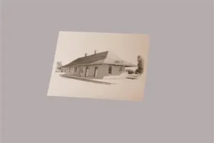 Cream postcard showing a black-and-white view of the Wells depot.