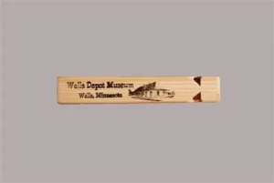 Wooden train whistle with a depot illustration and Wells Depot Museum lettering.
